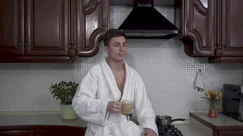 Young Man Drinking Coffee in Kitchen
