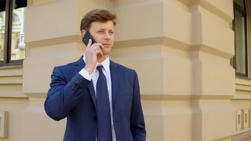 Man in Suit Talking on Phone Near Building