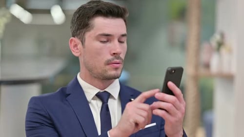 Excited Businessman Celebrates Good News on Smartphone