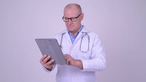 Mature Doctor Using Tablet in Hospital Setting
