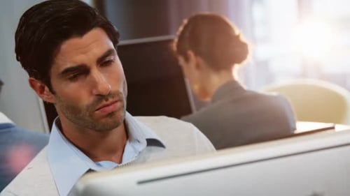 Chef d'entreprise de sexe masculin travaillant sur un ordinateur avec des collègues