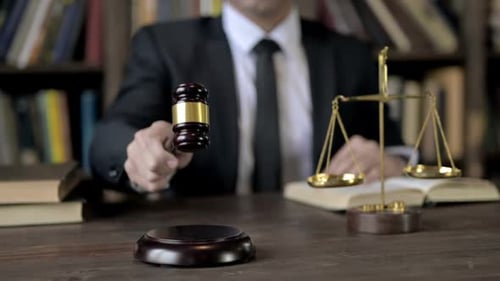 Primer plano de la mano del juez golpea el mazo en la sala del tribunal
