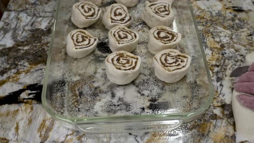 Uncooked Cinnamon Rolls Being Placed in Baking Pan
