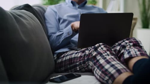 Man Using Laptop for Video Call on Couch