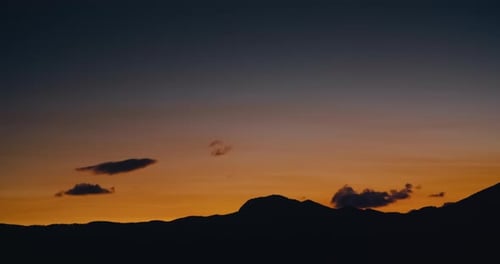 Mountain Silhouette on Sunset with Disappearing Clouds Shot in Timelapse