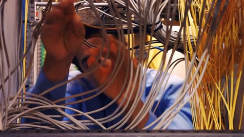 Man Working With Cables in Server Room