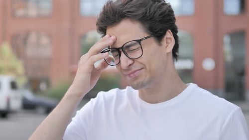 Man with Headache Rubs Forehead Outside