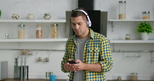 Man Dancing to Music in Bright Kitchen