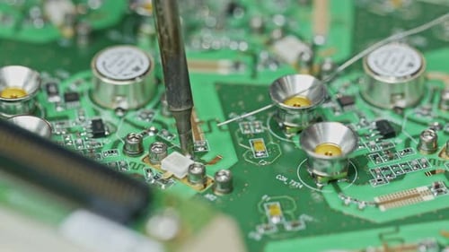 Close up of manual soldering of a large circuit board