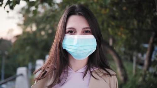 Woman in Surgical Mask in Urban Environment