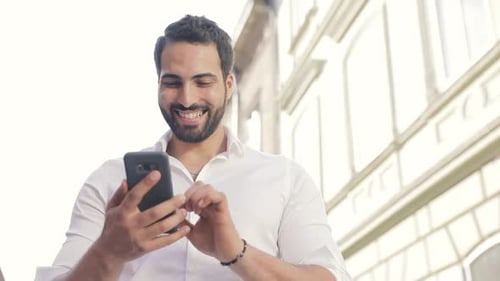 Happy Man Using Phone in City Environment