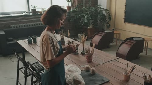 Woman Shaping Clay at Pottery Studio Workshop Table