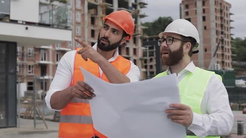 Engineers Reviewing Blueprints at Construction Site
