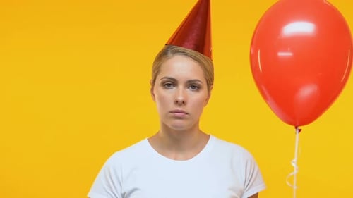 Sad Woman with Balloon at Birthday Party