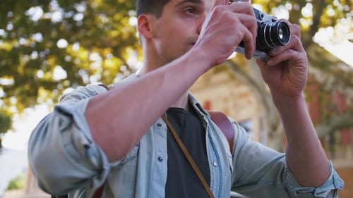 Close Up Shot of Young Attractive Handsome Man Tourist with Backpack Taking Photos on Vintage Camera