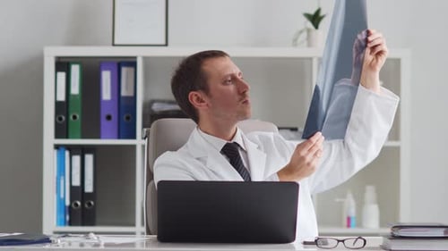 Professional medical doctor working in hospital office using computer technology.