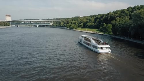 Boat Slowly Moving on Urban River on a Sunny Day