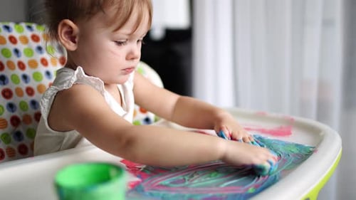 Little Girl Finger Painting with Vibrant Colors