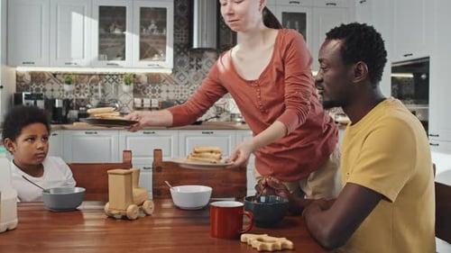 Family Eating Breakfast Together at Kitchen Table