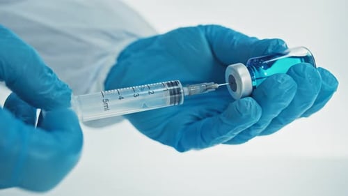 Drawing Blue Liquid into Syringe with Blue Gloves