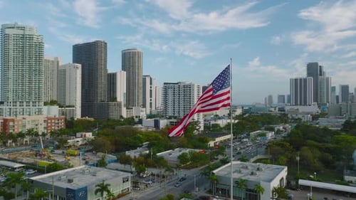 American Flag Waving Proudly in Urban Cityscape Aerial View