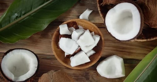 Coconuts and Pieces Displayed on Wood Surface