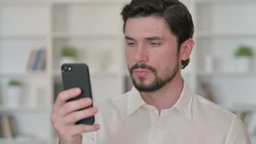 Young Adult Using Smartphone Indoors