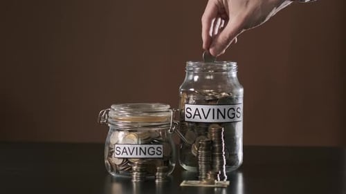 Coin Drops into Savings Jar Still Life