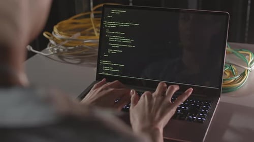 Unrecognizable Programmer Typing on Laptop Computer