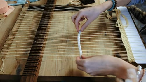Woman's Hands Weaving on a Loom Frame