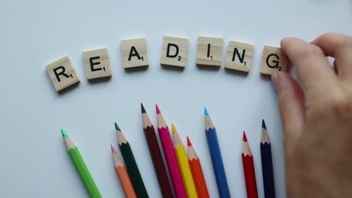 Word Reading Composing From Wooden Letters Tiles on White Background with Colorful Pencils