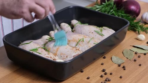 Chef Prepares Chicken Legs with Herbs in Kitchen