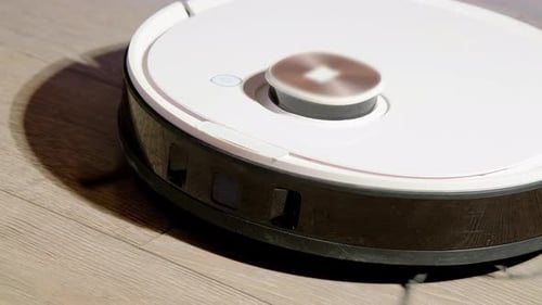 L'aspirateur robot avec indicateur clignotant nettoie le sol dans la pièce