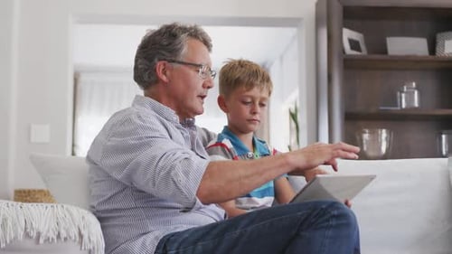 Adult and Child Looking at Tablet Together