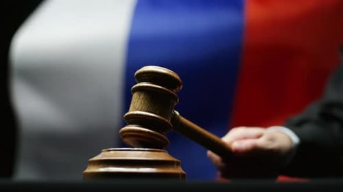 судья с молотком на фоне флага