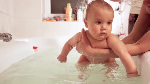 Adorable Baby Enjoying Bath Time with Loving Parent