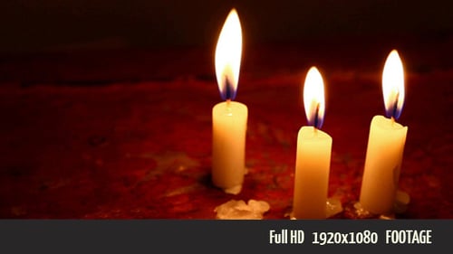 Candles Burning with Flickering Flames in the Dark