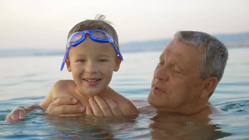 Child and grandfather bathing in the sea
