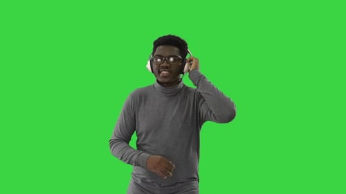Young Man Dances with Headphones on Green Screen