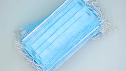 Stack of Light Blue Disposable Face Masks