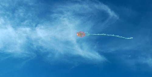Colorful Kite Flying High in a Blue Sky