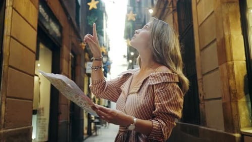 Woman Looks at Map in Narrow City Street