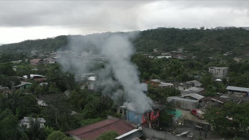 Vista aérea de una casa que está en llamas, con el nivel superior destruido