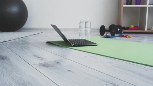 Laptop and Fitness Equipment on a Yoga Mat