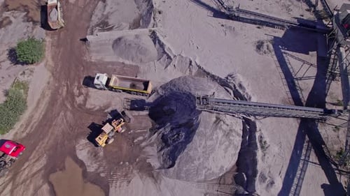 Excavator Loading Crushed Stone Into a Dump Truck in a Crushed Stone Quarry