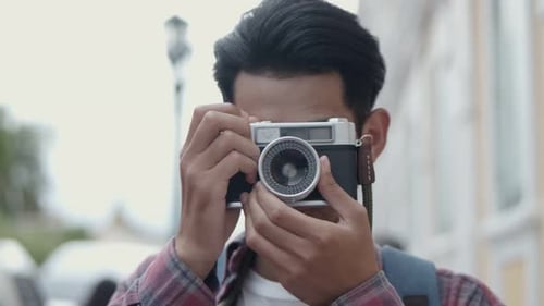 Young Adult Taking Photos with Vintage Camera