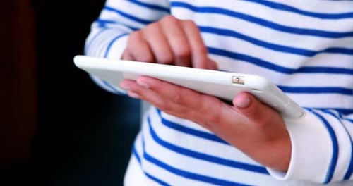 Mid-section of school kid using digital tablet