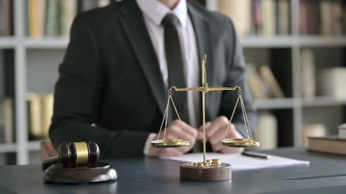 Close Up of Balance Scale and Gravel on Table with Lawyer