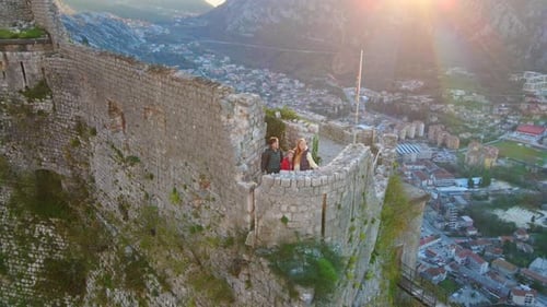 Family at Historic Castle Overlooking Scenic Town at Sunrise