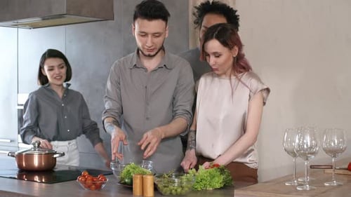 Friends Preparing Salad Together in a Kitchen